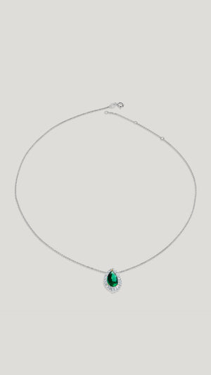 Emerald green pear shaped necklace in sterling silver encased in round brilliant and baguette shapes stones.