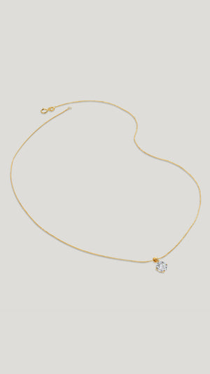 A classic four-prong solitaire pendant necklace set in 9k solid Yellow Gold with a glittering round brilliant-cut stone.