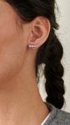 White gold plated sterling silver earrings with an ear climber silhouette and sparkling graduated round brilliant stones.