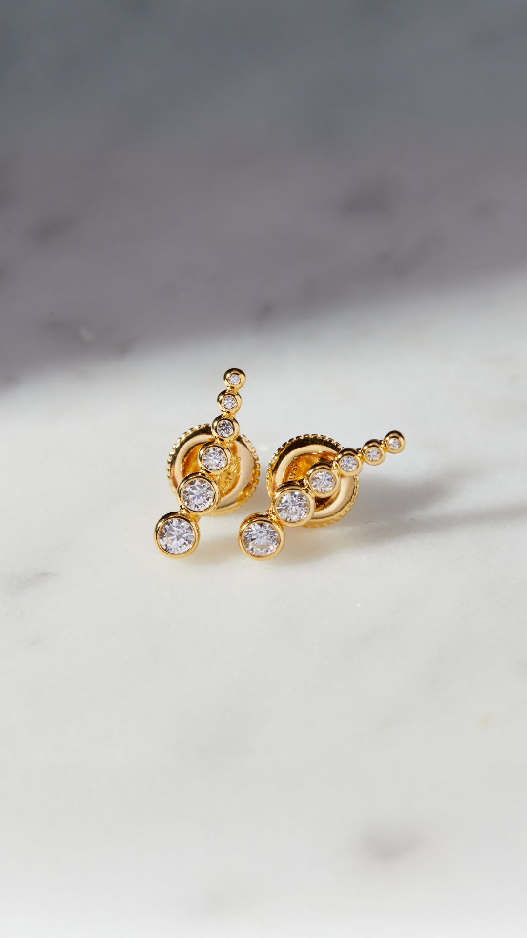 Ear climber gold earrings for women featuring graduated round stones. 