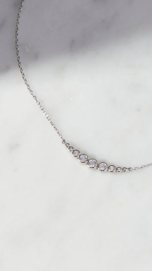 Carissa sterling silver necklace for women featuring a row of graduated round brilliant stones, complete with a slider closure.