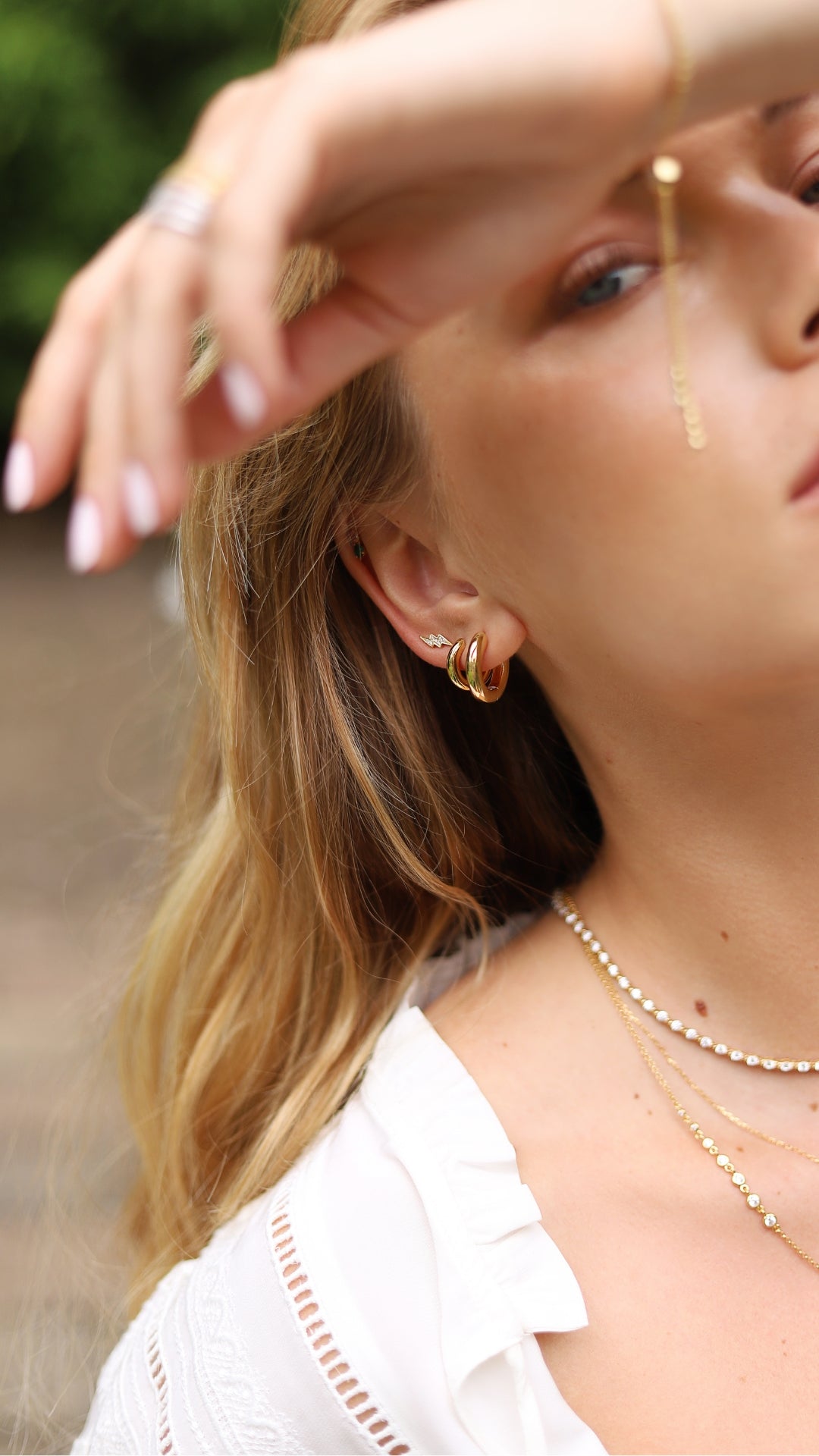 High-shine gold hoops stacked with little lightening bolt studs