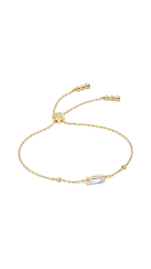 Gold slider bracelet for women featuring a single emerald cut stone in a bezel setting,