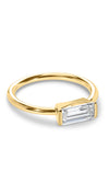 Simple gold solitaire ring for women featuring a single baguette stone finished in a unique setting.