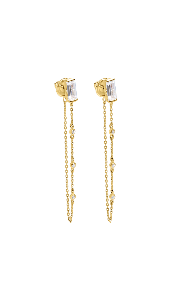 Gold earrings for women featuring a single baguette cut stone in a bezel setting with a delicate chain detail.