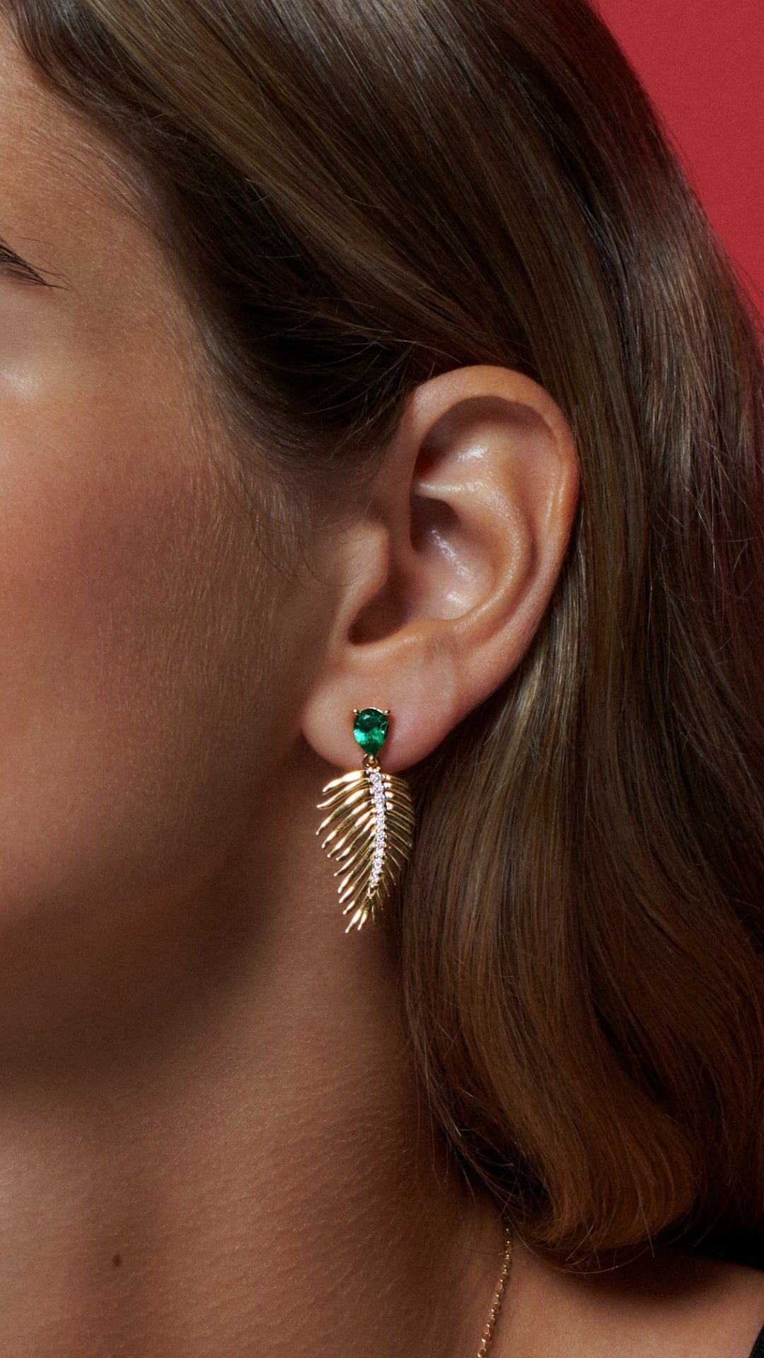 Gold vermeil palm earrings for women with emerald stone and palm leaf design.