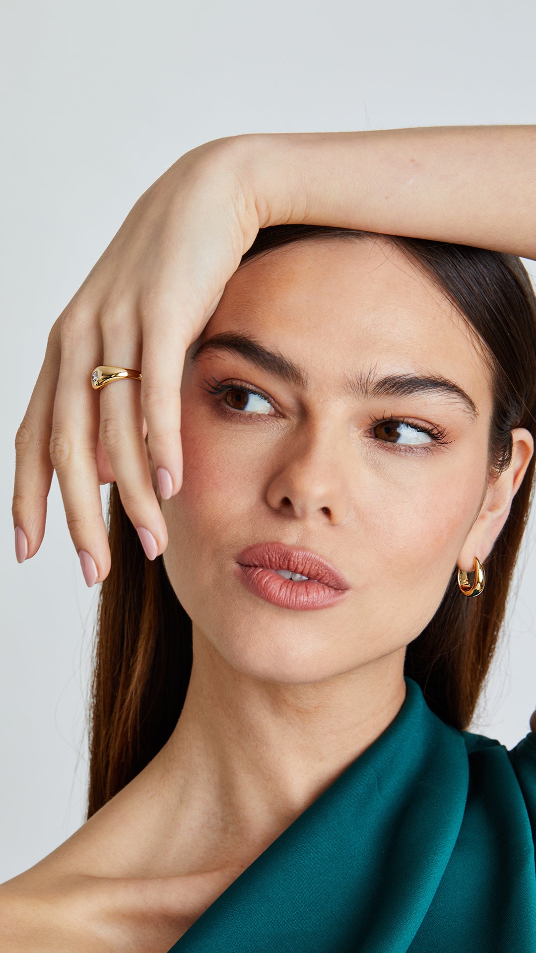 Classic gold teardrop hoop earrings styled with a matching gold signet ring