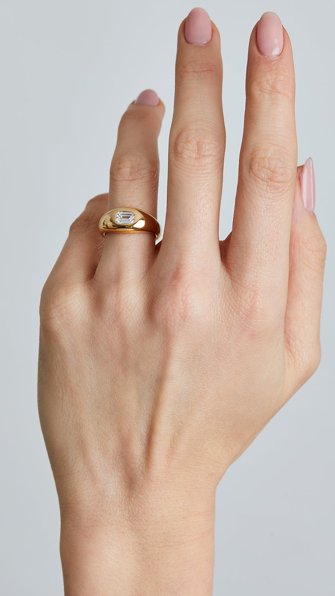 Minimalist signet ring crafted from sterling silver, featuring a striking emerald-cut gemstone in an 18K gold vermeil bezel setting.