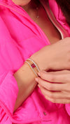 Tennis bracelets stacked with lab-grown pink cabochon stones on gold slider bracelet for women