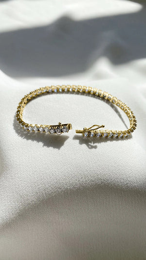 Vianne gold ladies tennis bracelet for sale featuring dazzling stones and a secure, 3-stage lock system.