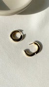 Close-up of polished gold vermeil hoop earrings with a seamless finish